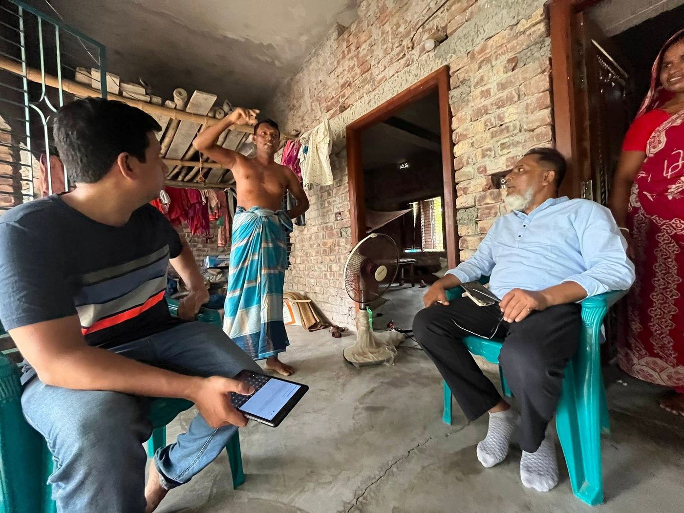 Researcher interviewing residents on a veranda