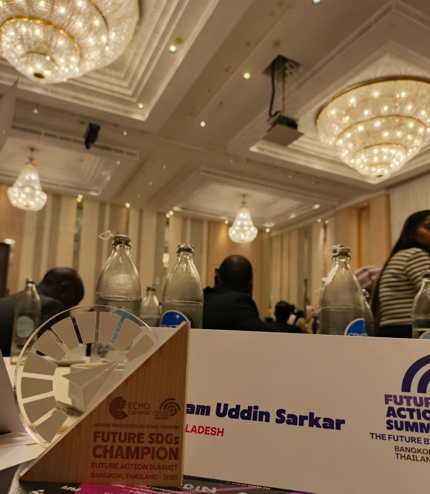 Future SDGs Champion trophy beside a name card reading Nijam Uddin Sarkar