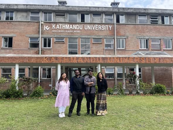 Uplift Probe and FECAM members standing in front of a Kathmandu University building